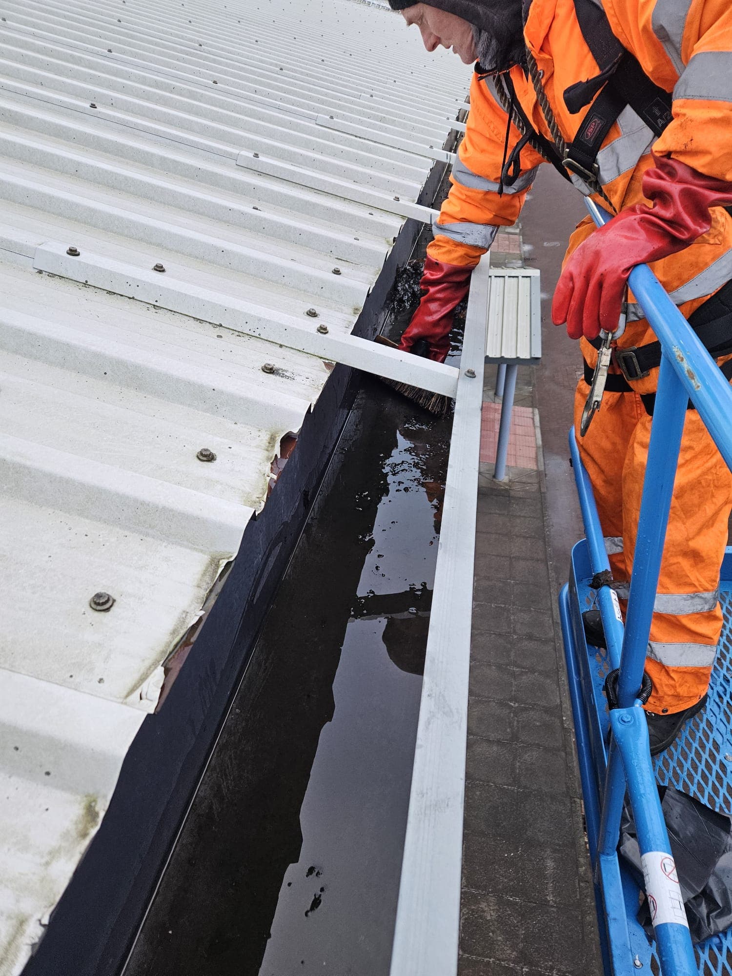 Struan gutter cleaning specialist on MEWP clearing commercial building gutters